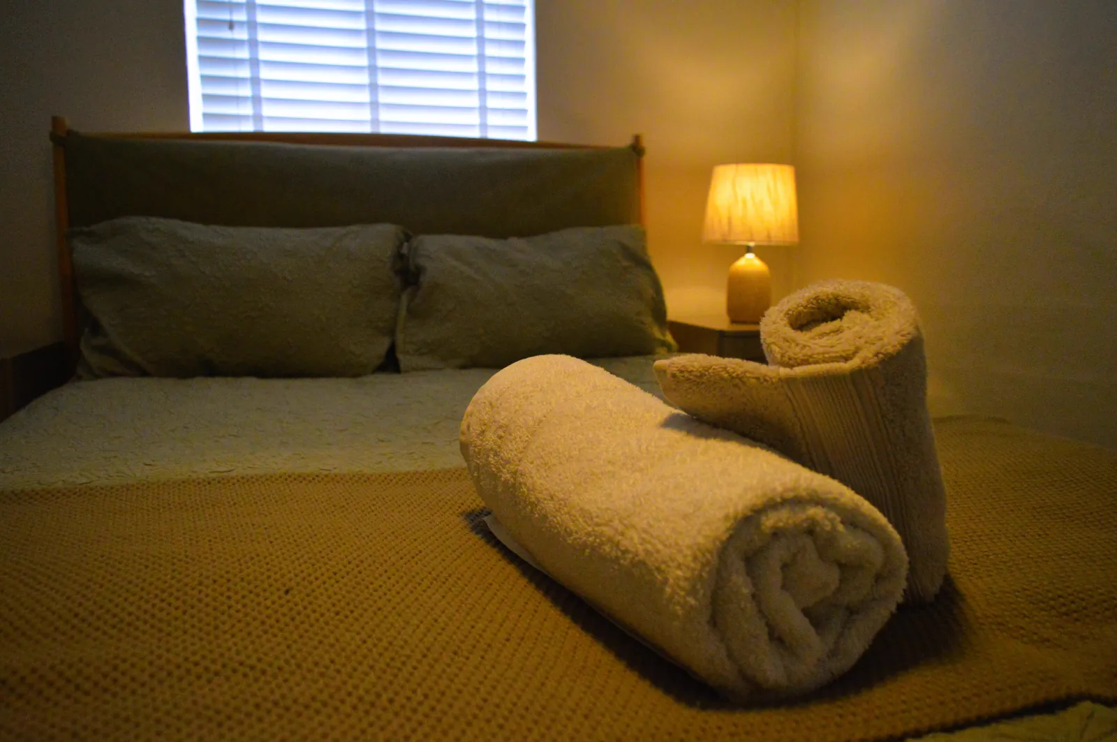 Airbnb bedroom with folded towels on the bed